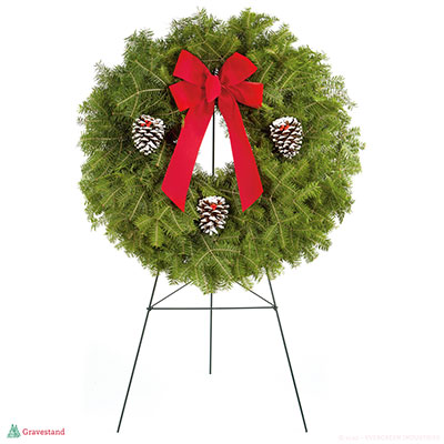 Cemetery evergreen Wreath on a grave stand. Red bow and three pine cones.